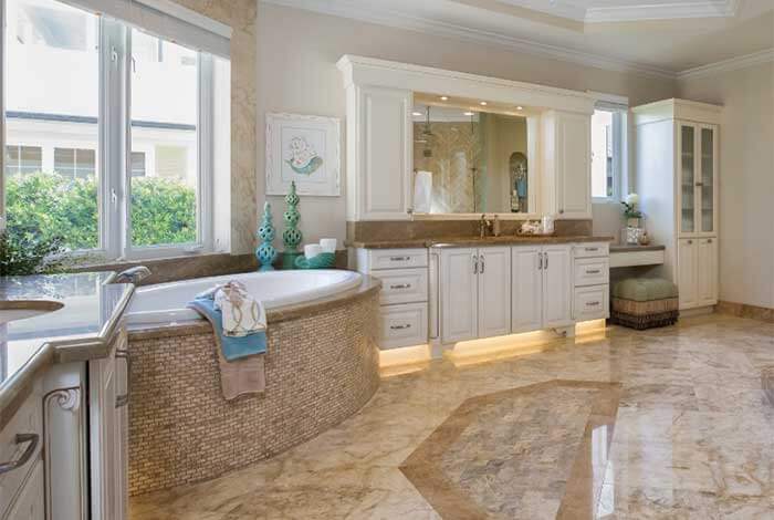 Luxurious bathroom featuring a large bathtub, white cabinetry, and ample natural light for a relaxing and stylish space.