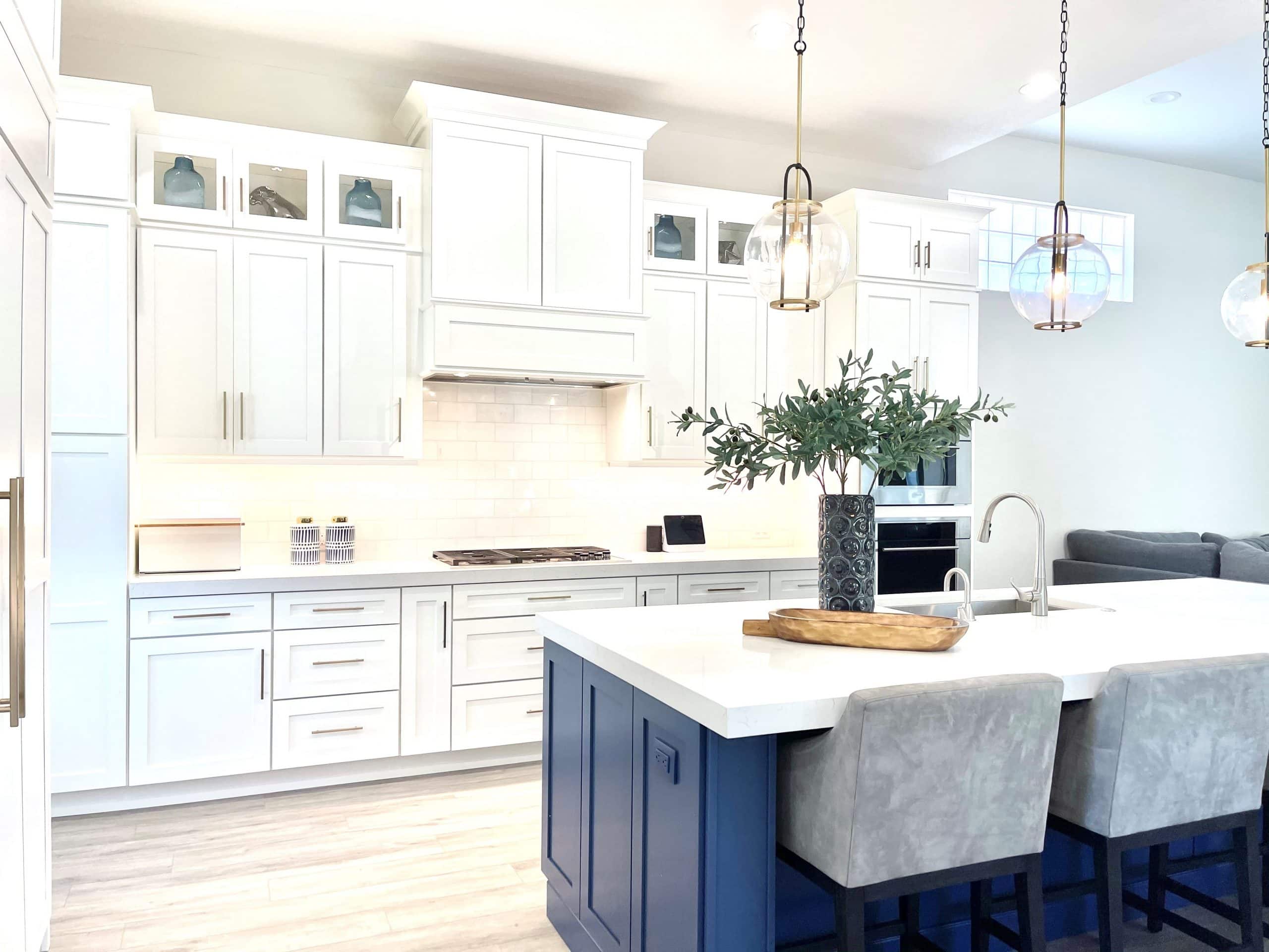 Modern white kitchen with island and pendant lighting, open-concept design, and cozy seating area. Bright, clean, and stylish for contemporary home interiors.