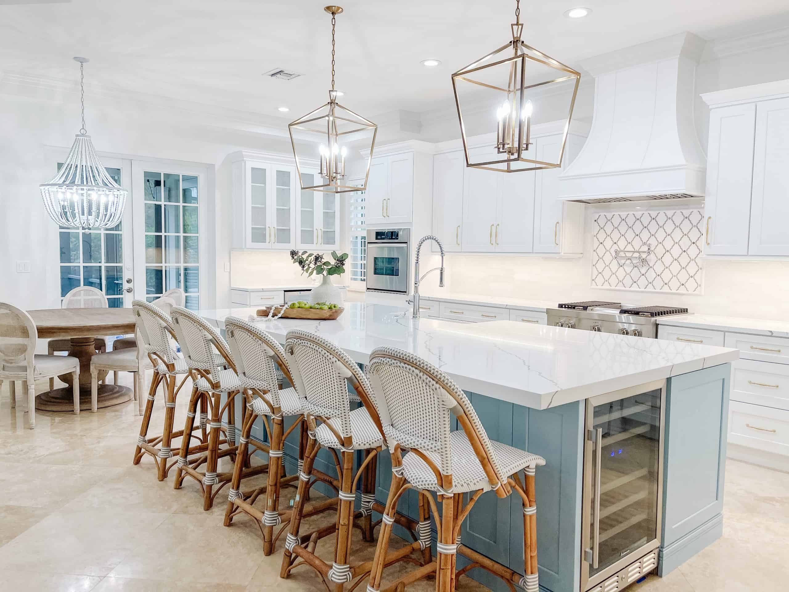 Modern white kitchen with island and bar stools for social cooking and dining. Bright, spacious, and stylish design featuring elegant lighting and contemporary cabinetry. Perfect for family gatherings and entertaining guests.