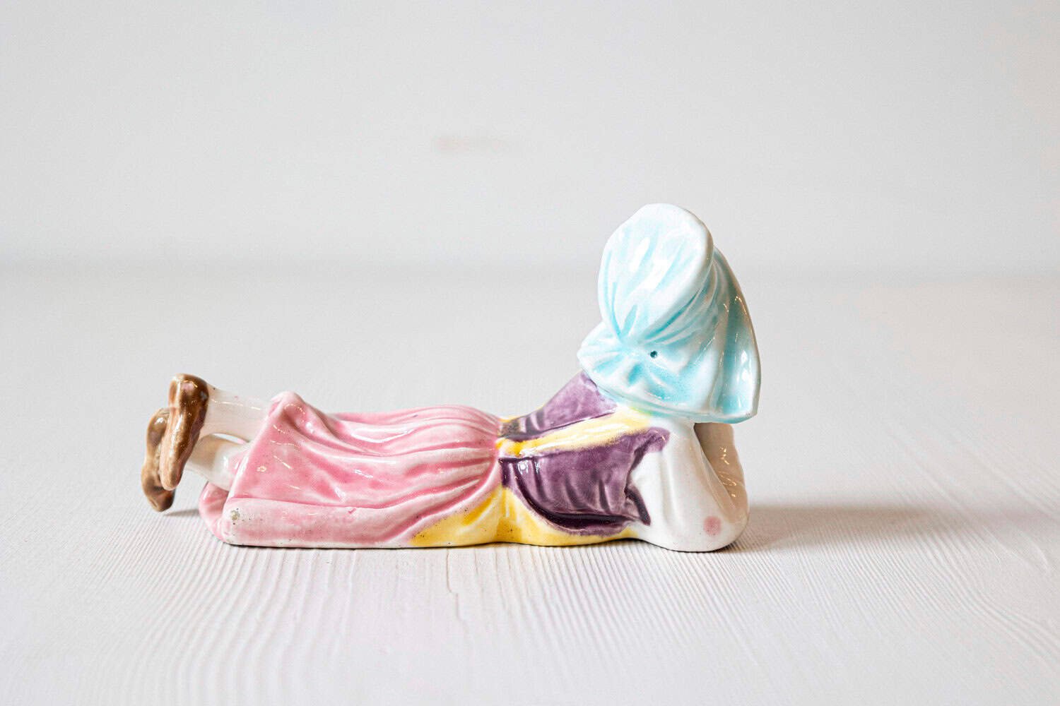 Petite English Porcelain Figurine Depicting a Young Girl Laying on the Ground - JAA