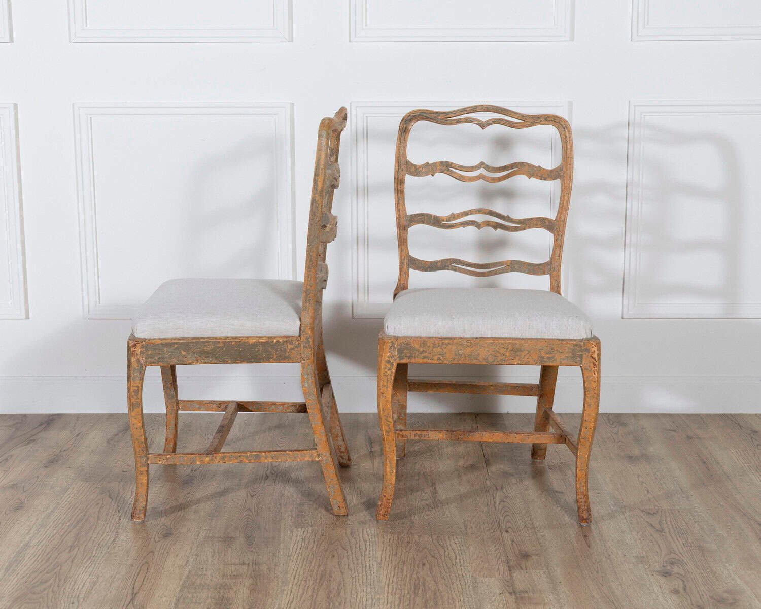 A pair of slender Gustavian chairs with smiling details, scraped to original paint and newly covered in linen. Circa 1780 - JAA