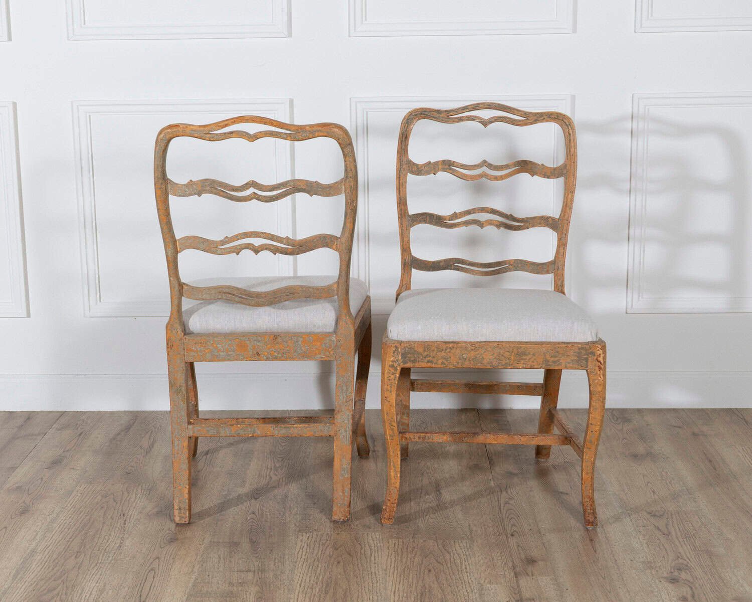 A pair of slender Gustavian chairs with smiling details, scraped to original paint and newly covered in linen. Circa 1780 - JAA
