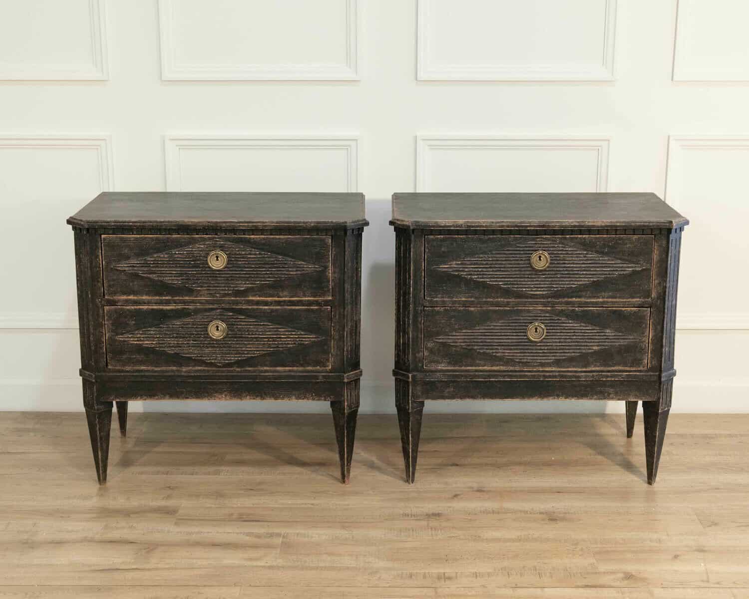 A pair of black Gustavian-style chests of drawers. - JAA