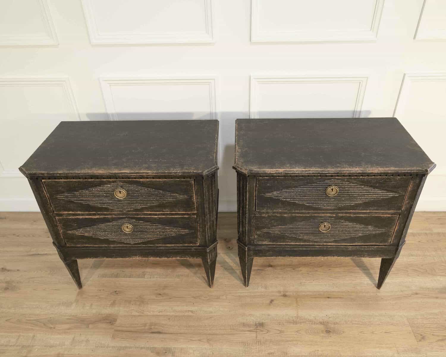 A pair of black Gustavian-style chests of drawers. - JAA