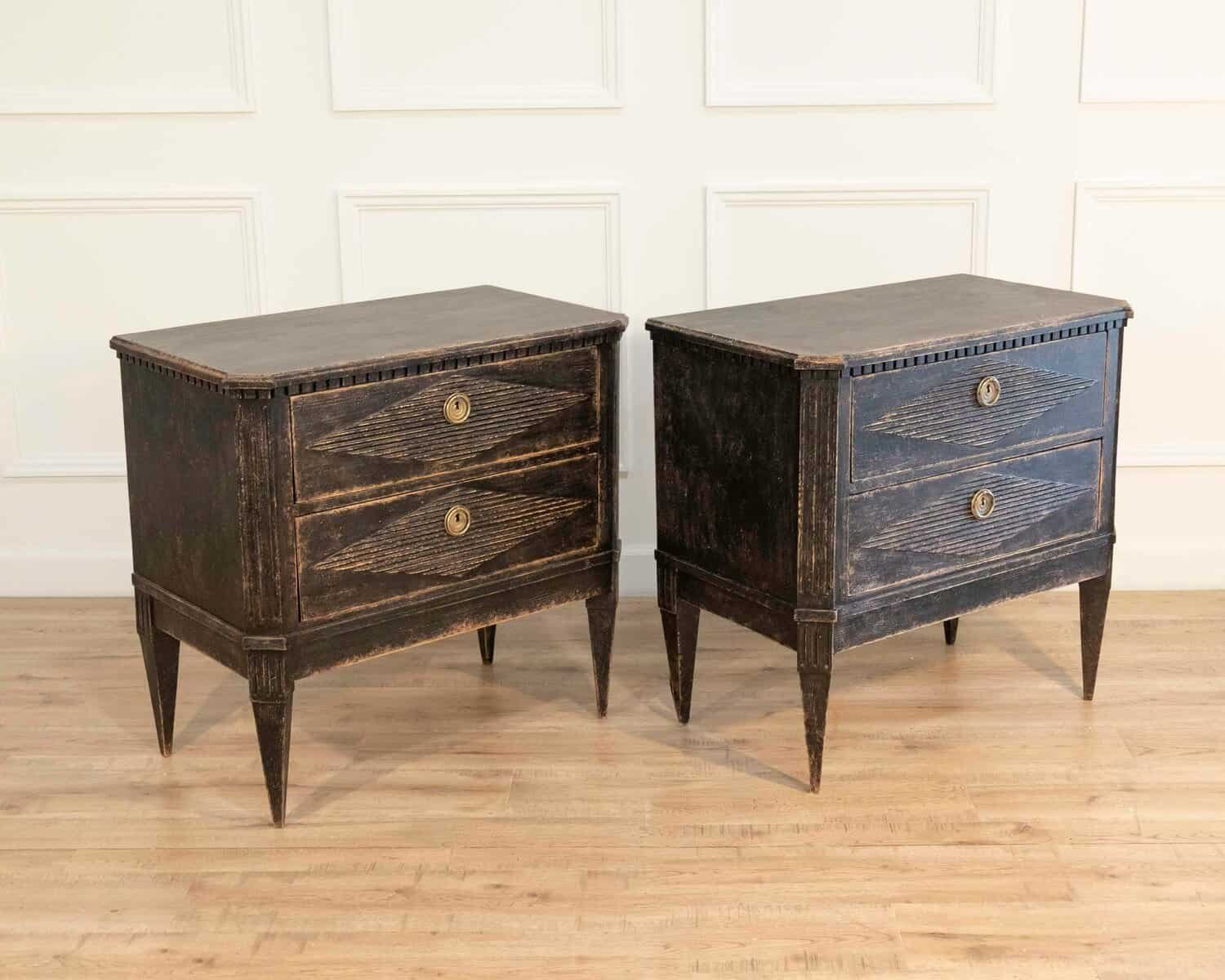 A pair of black Gustavian-style chests of drawers. - JAA
