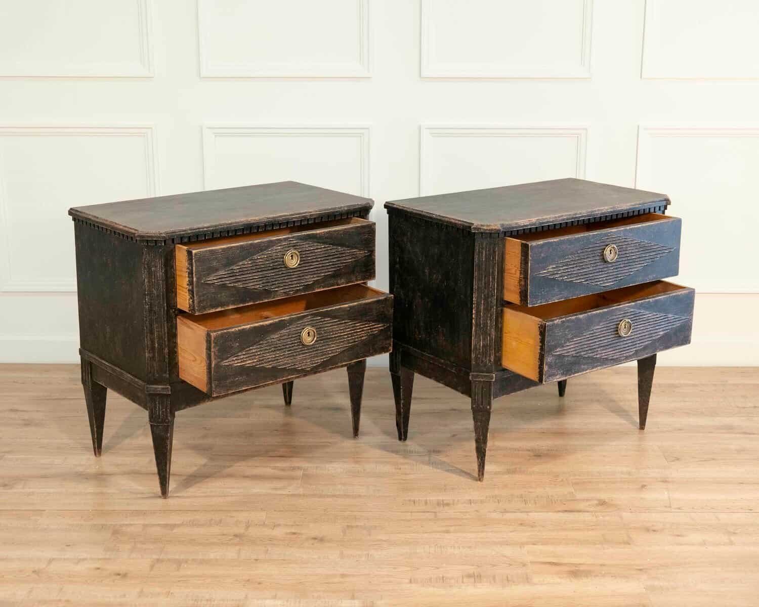 A pair of black Gustavian-style chests of drawers. - JAA