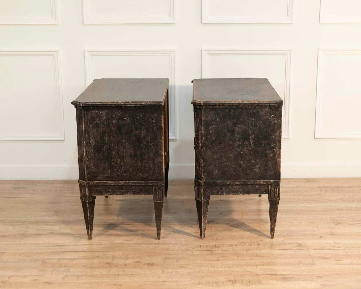 A pair of black Gustavian-style chests of drawers. - JAA