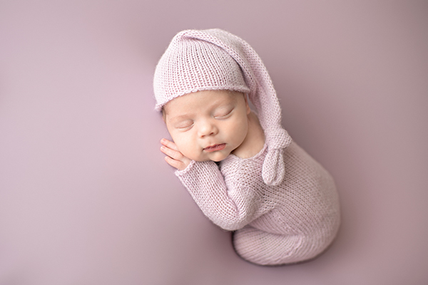 Newborn Photographer Maryland baby in pink romper with sleepy hat