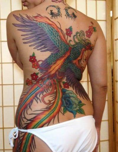 Jesse Britten Tattoo, St. Augustine, FL Woman with a vibrant phoenix Japanese tattoo covering her back.