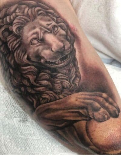 Jesse Britten Tattoo, St. Augustine, FL Lion statue tattoo on arm, detailed black and gray ink