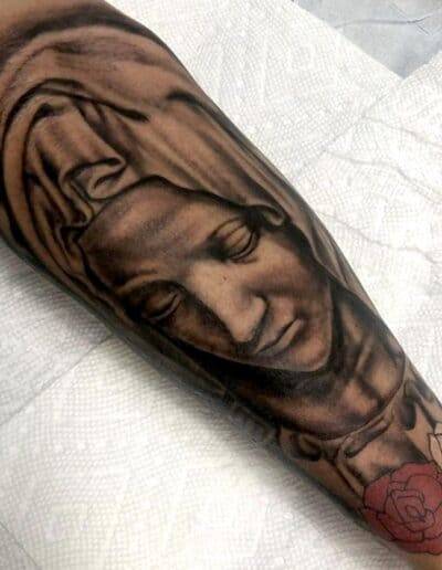 Jesse Britten Tattoo, St. Augustine, FL Forearm tattoo of Virgin Mary with roses. Jesse Britten Tattoo.