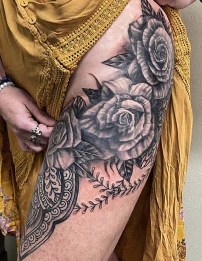 Jesse Britten Tattoo, St. Augustine, FL Thigh tattoo featuring roses and mandala design in black and grey ink.