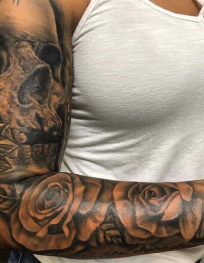 Jesse Britten Tattoo, St. Augustine, FL Skull and roses tattoo on woman's arm, black and grey ink.