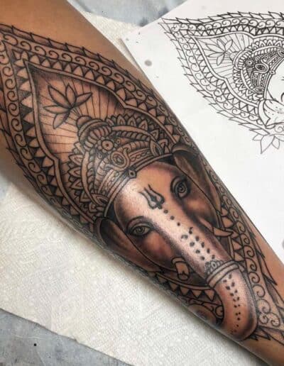 Jesse Britten Tattoo, St. Augustine, FL Ganesha tattoo on forearm with intricate border design, possibly by Jesse Britten Tattoo.