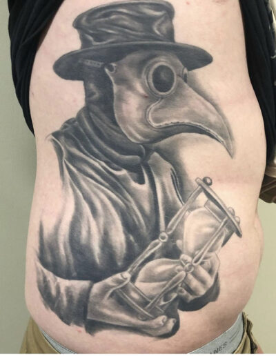 Jesse Britten Tattoo, St. Augustine, FL Plague doctor tattoo holding hourglass on torso
