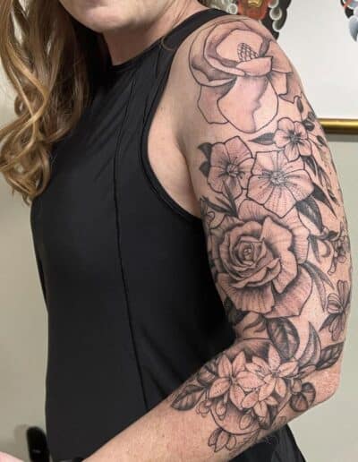 Tattoo of flowers and a rose on a woman's arm in St Augustine, Florida.