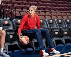 A sports psychologist talking with an athlete in a stadium setting to build mental resilience.