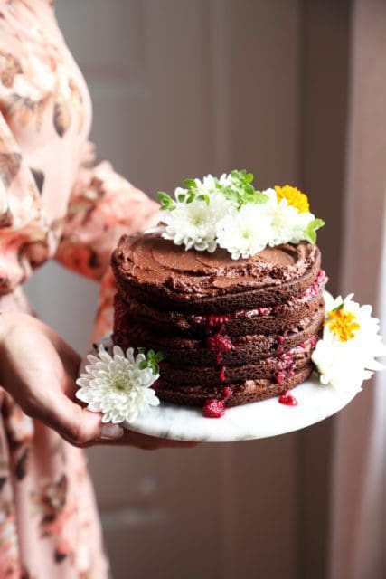 a layered chocolate cake on a white plate with flowers