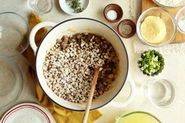 black eyed peas in a skillet with sausage and onions