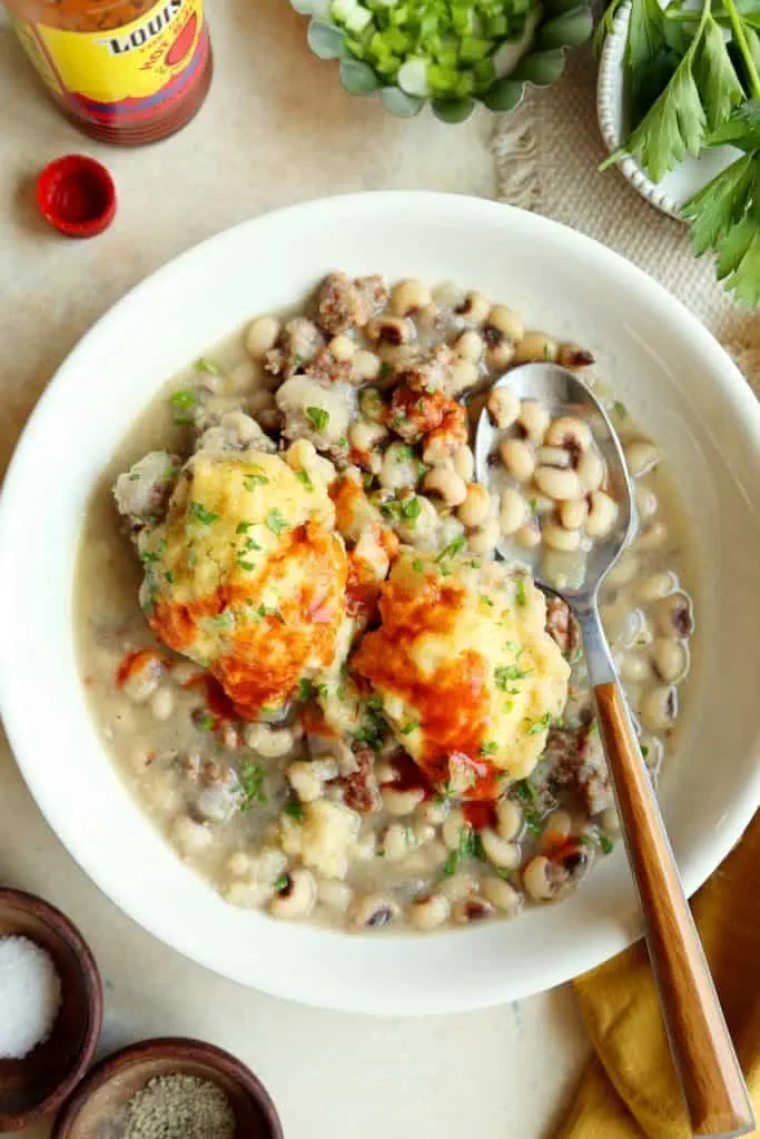 a bowl of black eyed peas with cornbread dumplings.