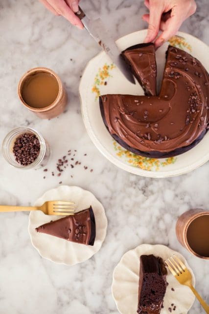 a slice of decadent chocolate cake on a white plate.