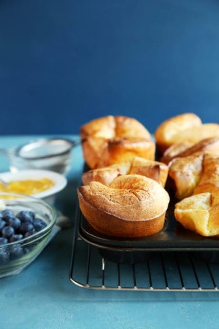 Side view of baked popovers rising from the muffin pan