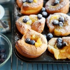 Christmas morning popovers sprinkled with blueberries in the pan