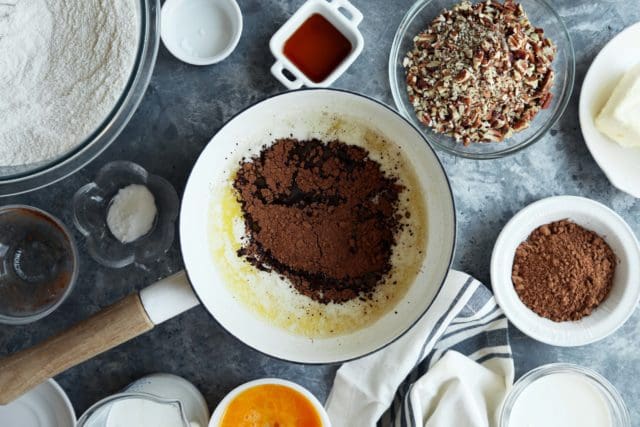 Cocoa powder and melted butter in a pan for Texas Sheet Cake.