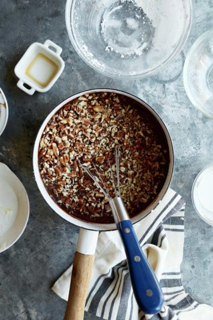 Pot with chocolate frosting and chopped pecans.