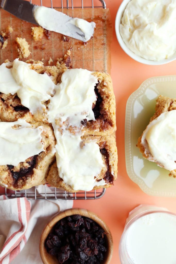 Frosted cinnamon rolls on a cooling rack.