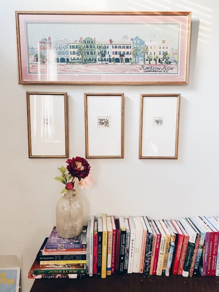 books on a bench with framed art above