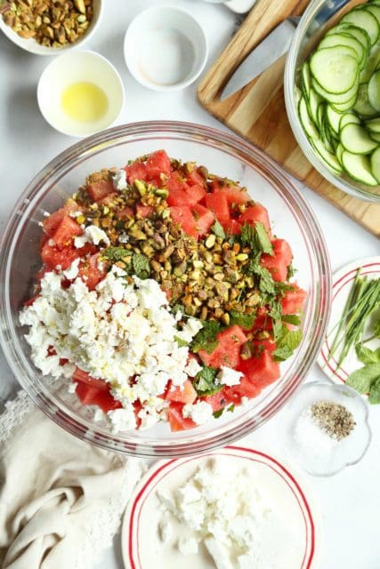 All ingredients for an easy watermelon salad in a large bowl.