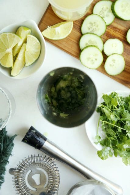 Cucumber and cilantro muddled in a cocktail shaker.