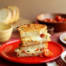 Lasagna Grilled Cheese Sandwiches sliced in half and oozing melted cheese.