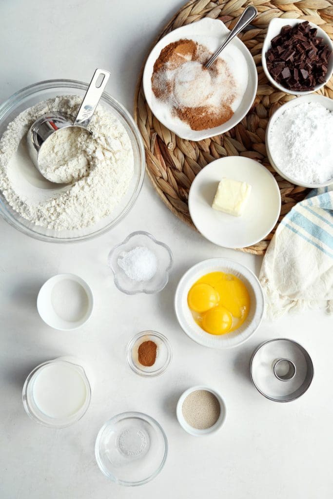 Ingredients for classic doughnuts recipe in small bowls.