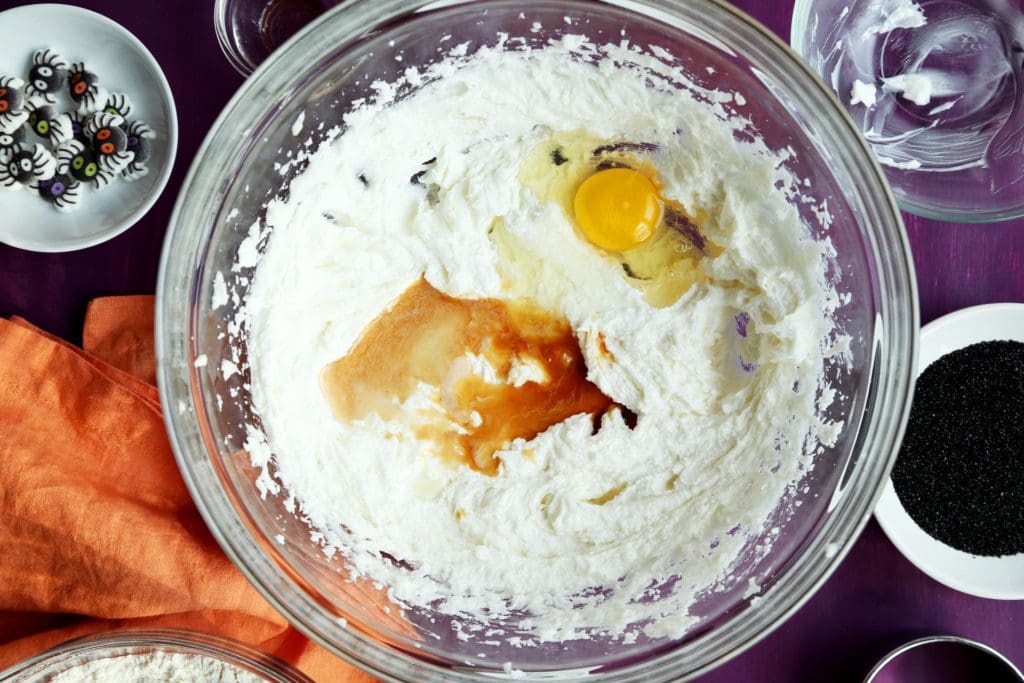 Egg and vanilla extract in sugar and fat for Halloween sugar cookie recipe.