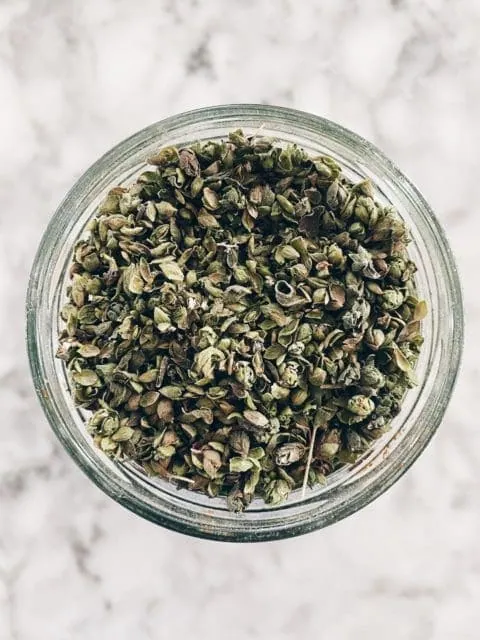 Close up image of dried oregano in jar.