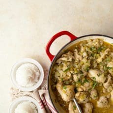 Smothered chicken recipe in a red pan with rice.