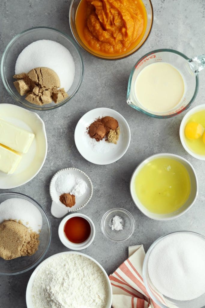 Ingredients for an easy pumpkin pie recipe in small bowls on grey board.