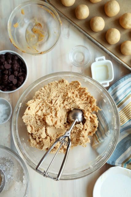 Peanut butter, butter, and powdered sugar mixed in a glass bowl.