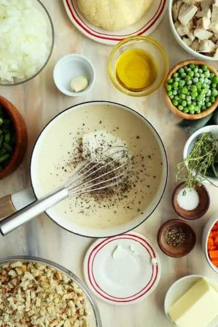Adding milk and seasoning to roux for turkey pot pie.