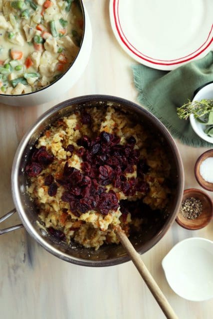 Adding dried cranberries to stuffing.