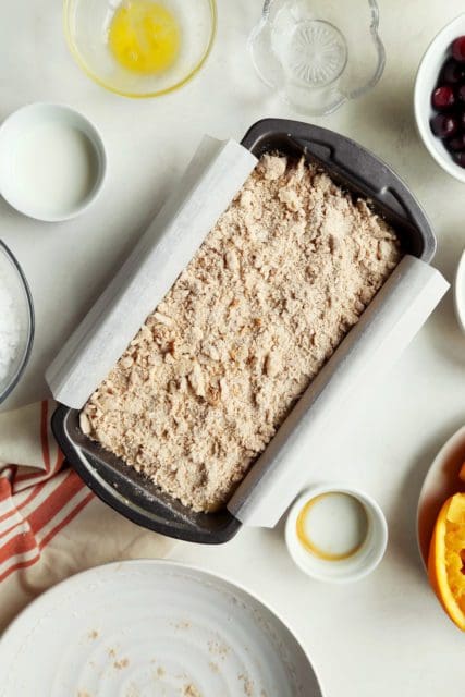 Crumble added to cranberry orange bread in pan.