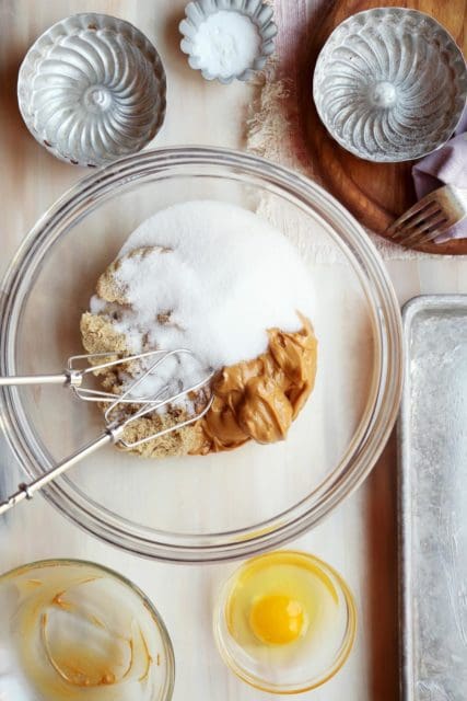 Sugars and peanut butter in a clear bowl for peanut butter cookies.