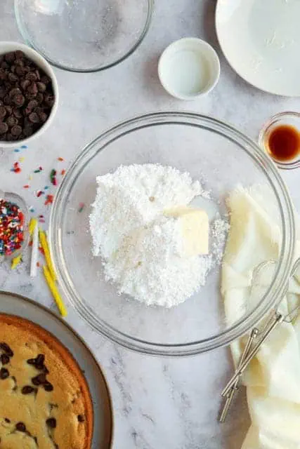 Powdered sugar and butter in a bowl for buttercream for cookie cake recipe.