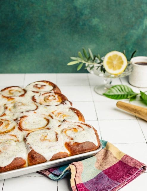 A whole pan of frosted lemon poppy seed rolls.