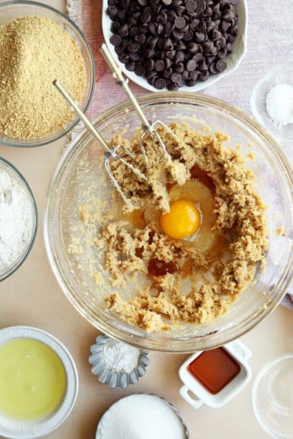 Butter, sugar, eggs and vanilla in a mixing bowl with beaters.