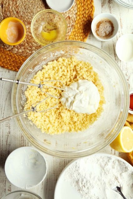 Adding sour cream to doughnut batter.