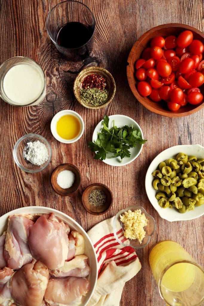 Ingredients for Marry Me Chicken in small bowls on a wooden board.