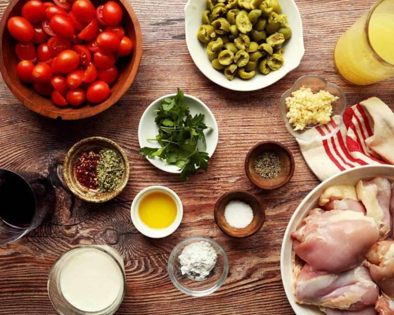 Ingredients for Marry Me Chicken in small bowls on a wooden board.